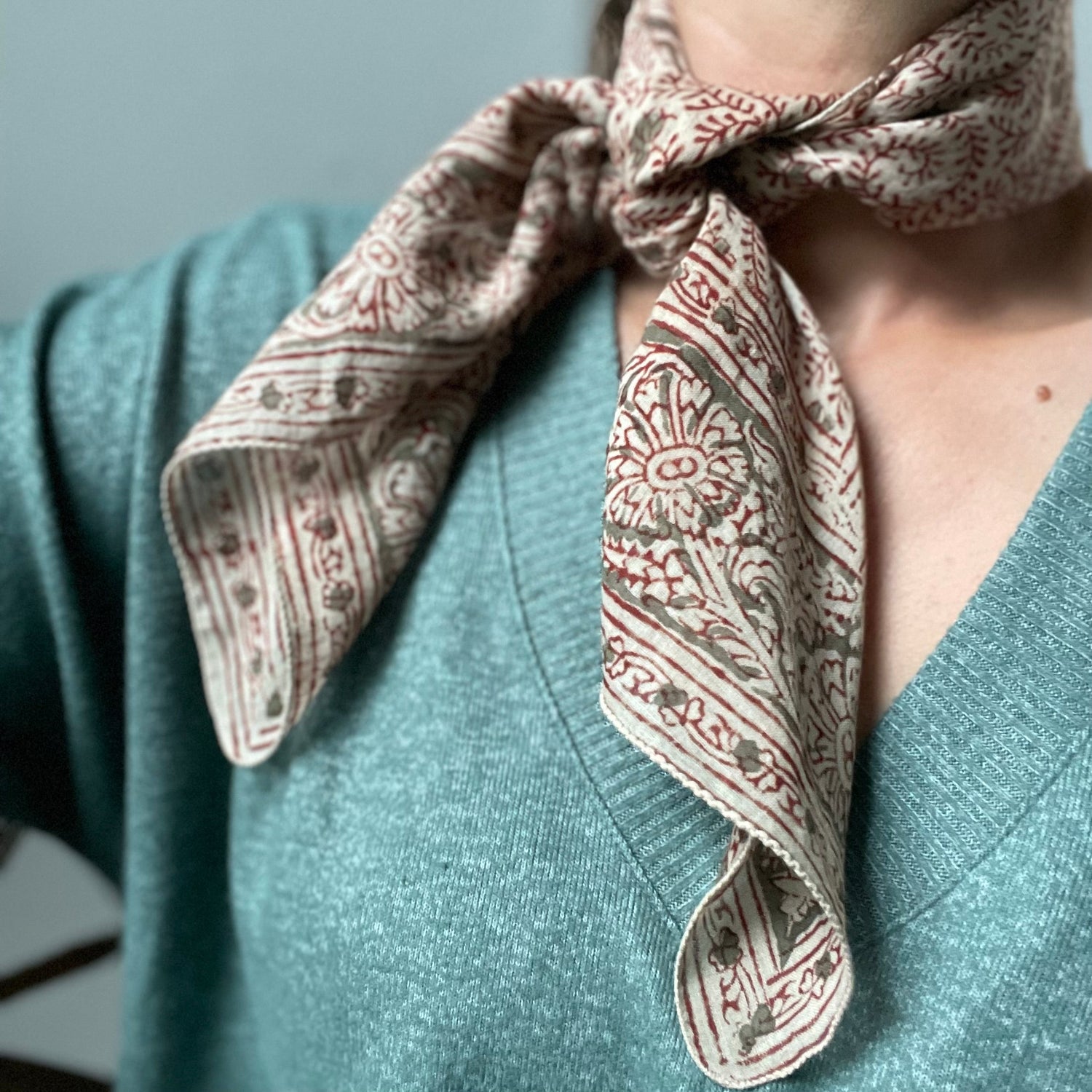 Close-up of beautiful floral bandana worn around woman's neck as a fashion accessory.